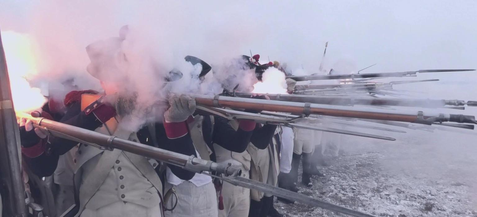 Historická scéna s řadou pušek